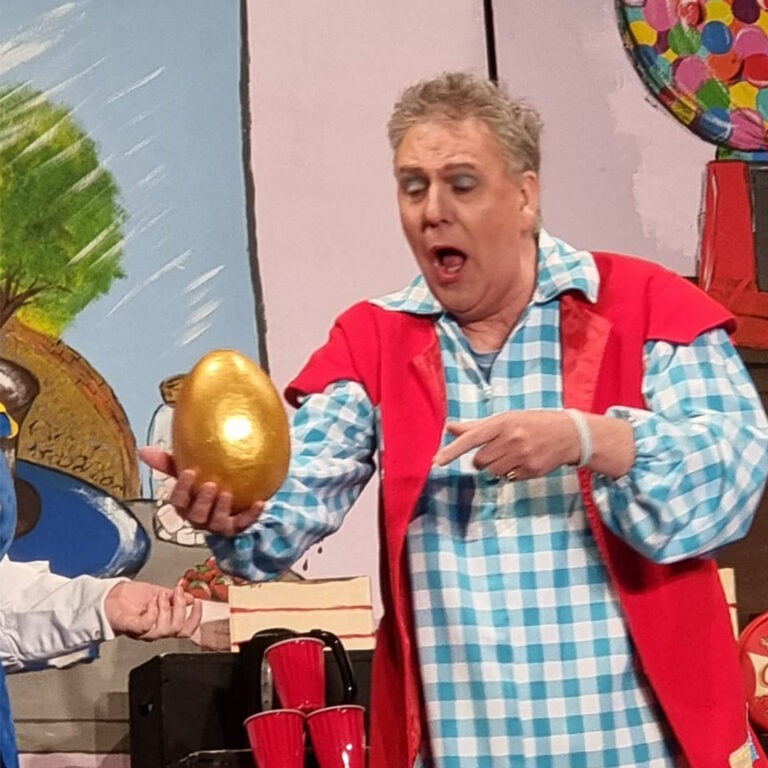 Peter Cooksley holding the golden egg in Spam Productions traditional Pantomime play